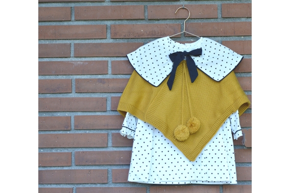 Poncho de punto con pompones